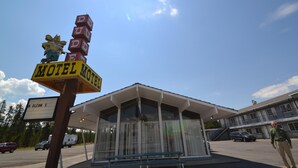 Et motel under en klarblå himmel, med et skilt der siger "Motel".