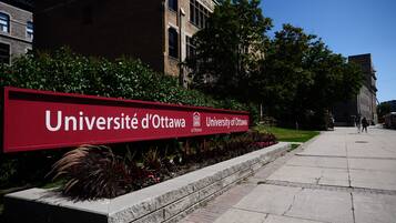 A sign for the Université d'Ottawa with a stone pathway and greenery in the foreground.