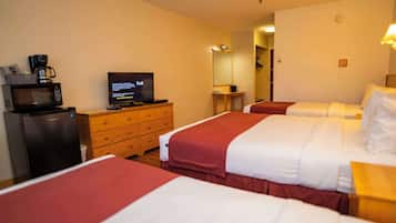 A hotel room with two beds, a TV, a microwave, and a wooden dresser.
