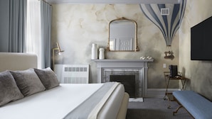 A hotel room with a large bed, a fireplace, a mirror, and a television. - The Franklin on Rittenhouse, A Boutique Hotel (Philadelphia)