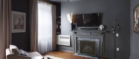 A modern living room with a fireplace, a television, and a sofa.