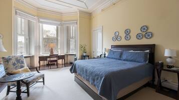 Un dormitorio con una cama grande, un escritorio y una silla.