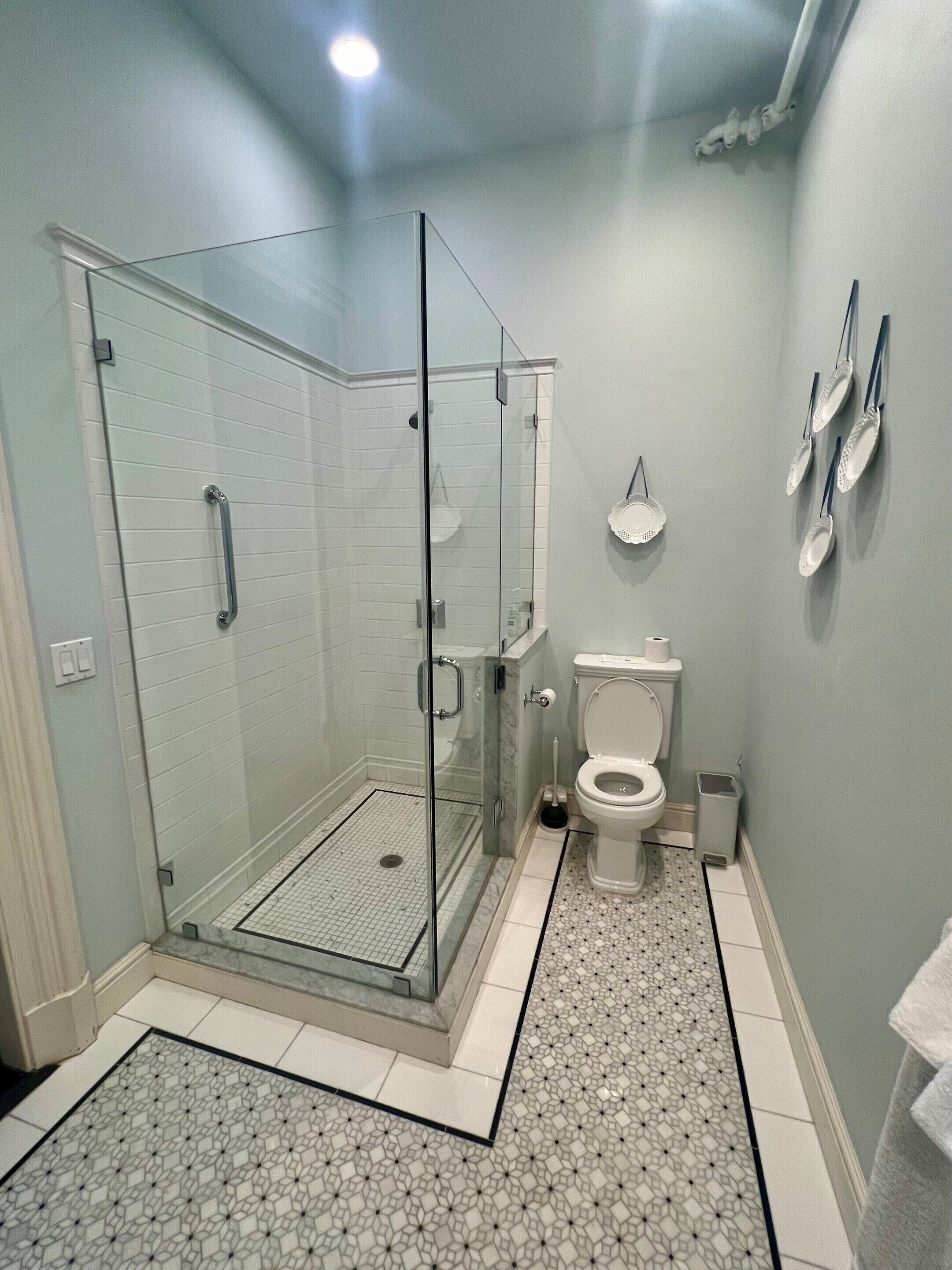 Un baño moderno con ducha de vidrio, inodoro y lavamanos.