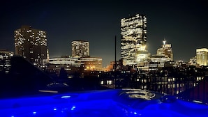 A city skyline at night with illuminated buildings. - Clarendon Square (Boston)