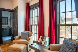 A cozy living room with a sofa, armchair, and a coffee maker on a table. - Addison Choate Inn (Rockport)