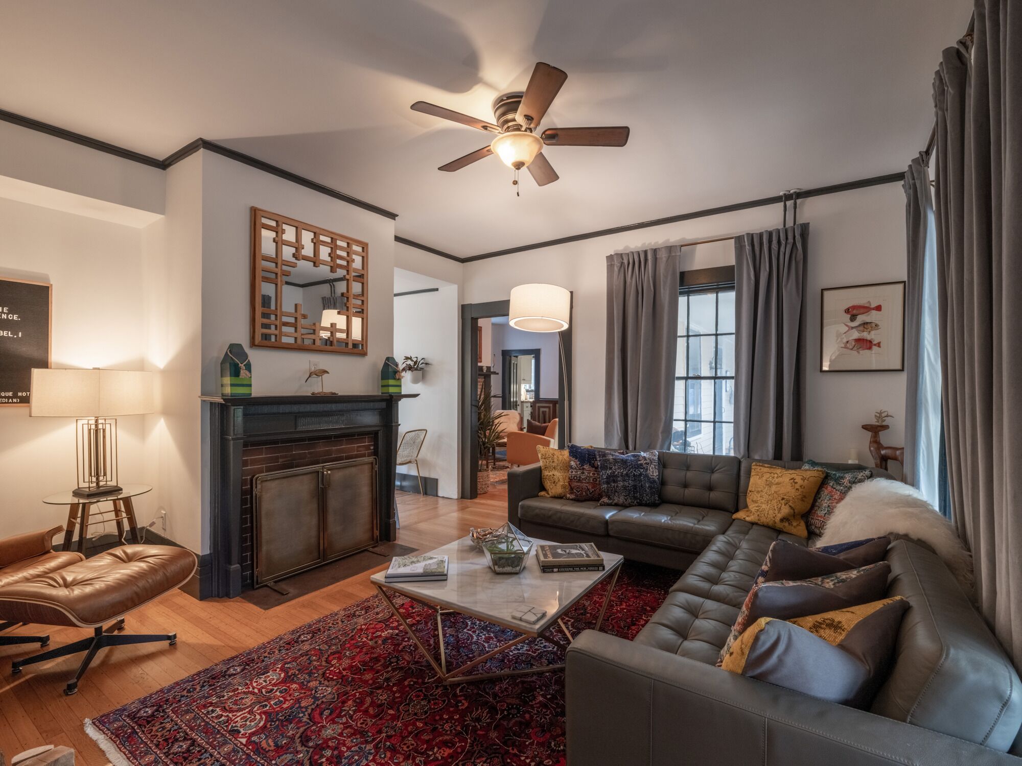A modern living room with a fireplace, leather sofa, and a coffee table.