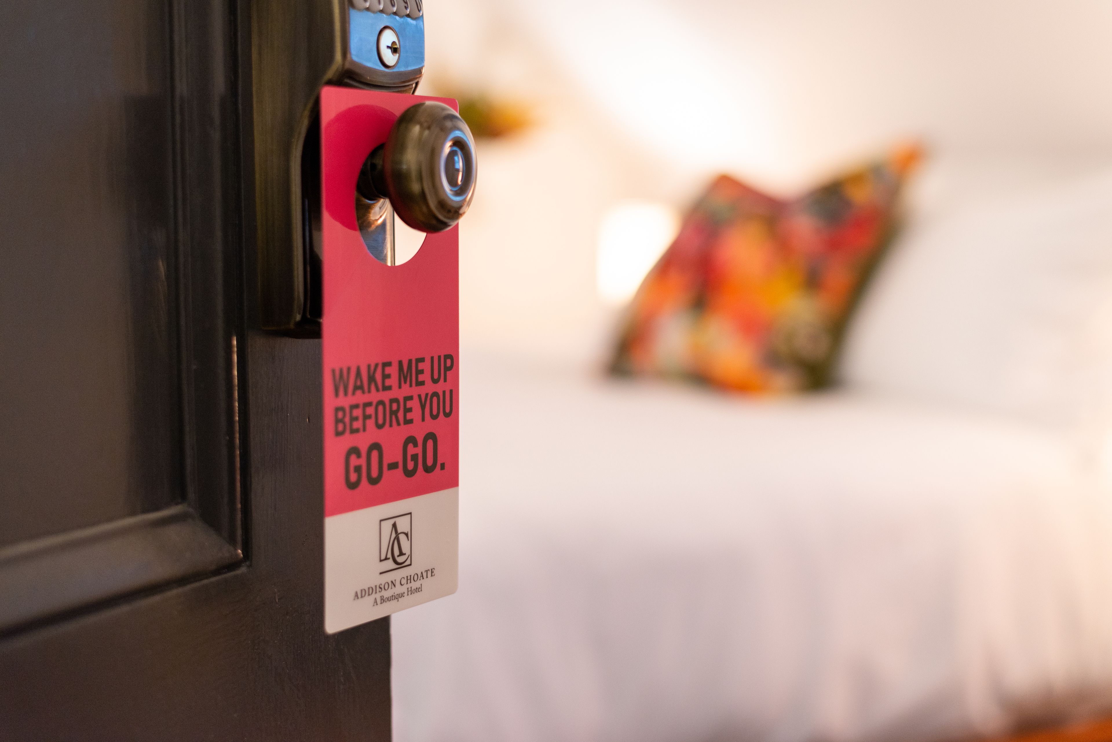 A door with a sign that reads "WAKE ME UP BEFORE YOU GO-GO."