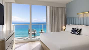 A hotel room with a large window, a bed, a nightstand, and a TV.