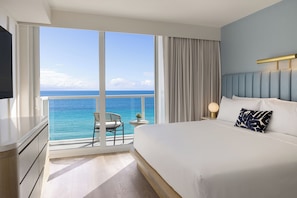 A hotel room with a large window, a bed, a nightstand, and a TV. - The Sunny Miami Sunny Isles Beach,Curio Collection by Hilton (Sunny Isles Beach)