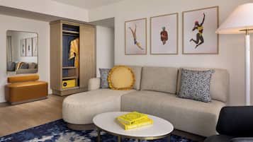 A modern living room with a sofa, a coffee table, a bookshelf, and a mirror.