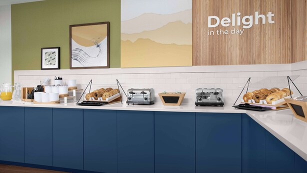 A breakfast bar with various food items and kitchen appliances.