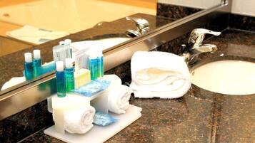 Un lavabo de salle de bain avec des articles de toilette et des serviettes.