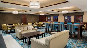 A hotel dining area with multiple tables and chairs, a sofa, and a patterned carpet. - Holiday Inn Express & Suites Sherwood Park-Edmonton Area by IHG (Sherwood Park)