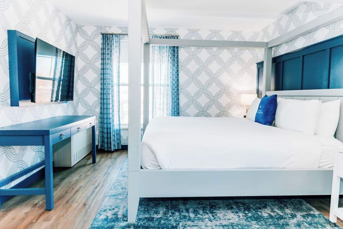 Una habitación de hotel moderna con una cama grande, un escritorio y un televisor.