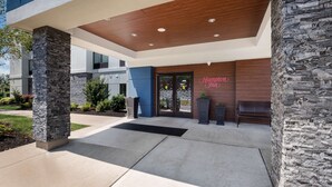A modern hotel entrance with a stone facade, a wooden ceiling, and a clear view of the Hampton Inn sign. - Hampton Inn Princeton (Princeton)