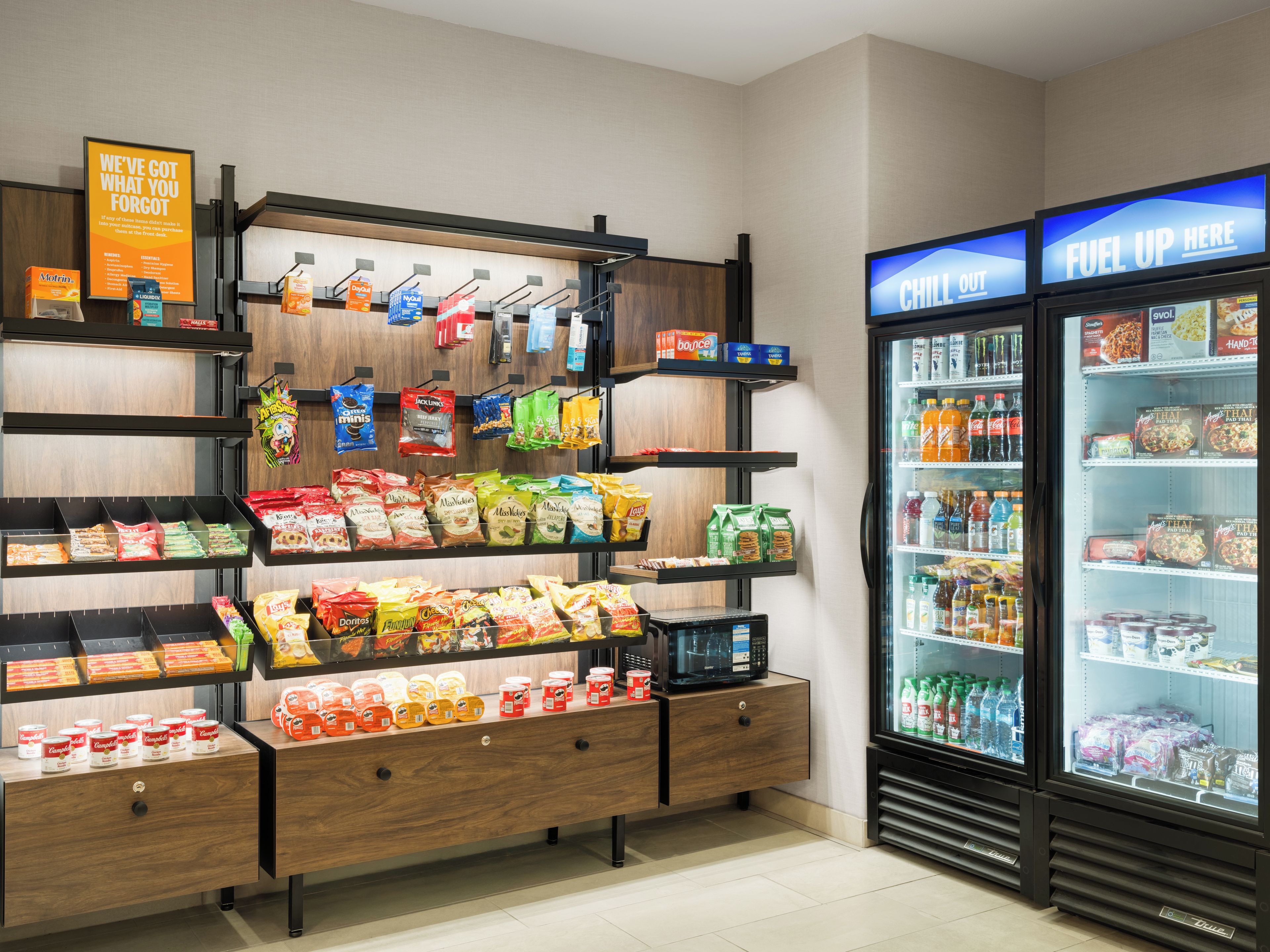 Une épicerie dont les rayons sont remplis d’en-cas, avec un four à micro-ondes et un réfrigérateur vitrine.