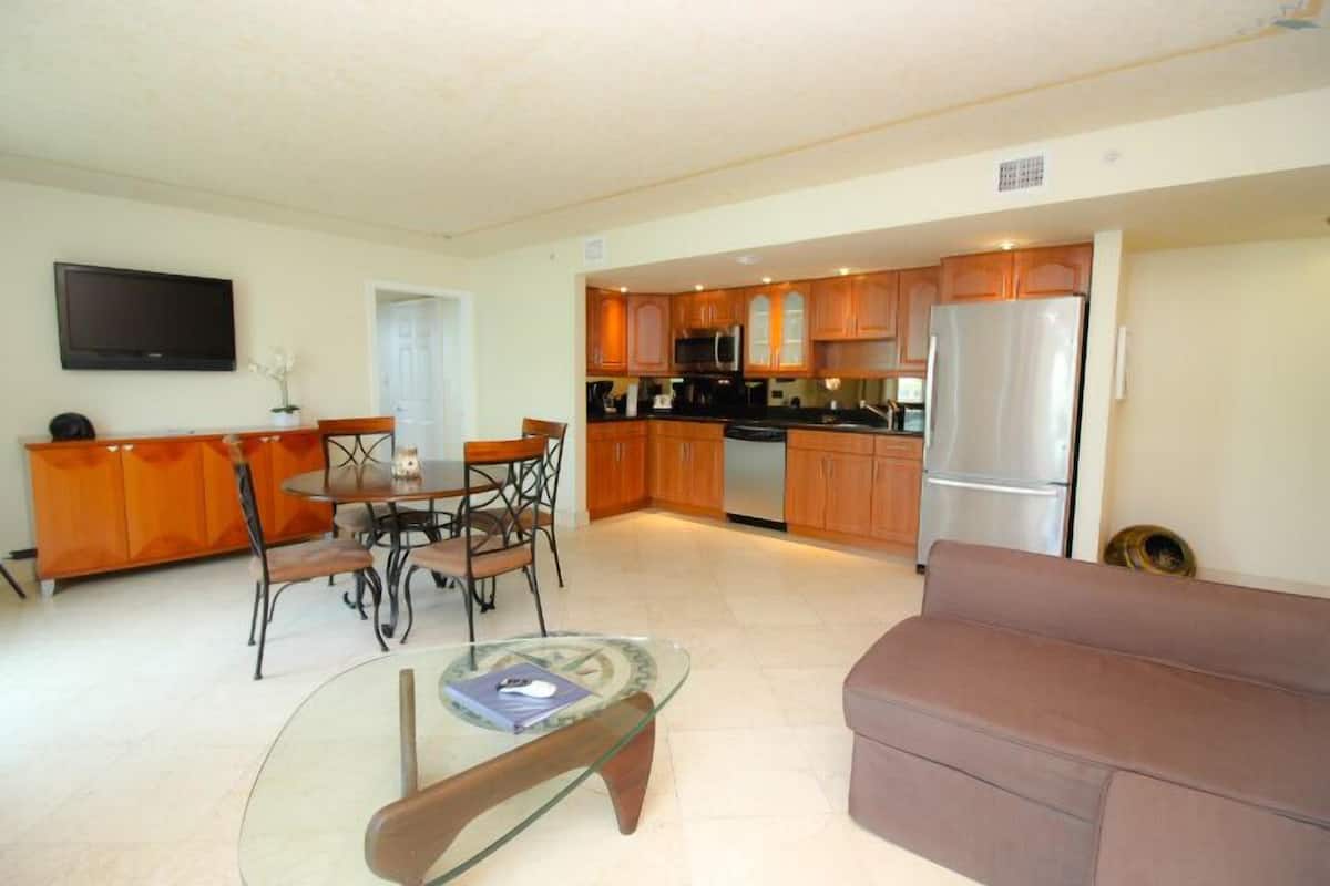 Un espacio habitable compacto con comedor, kitchenette y zona de estar.