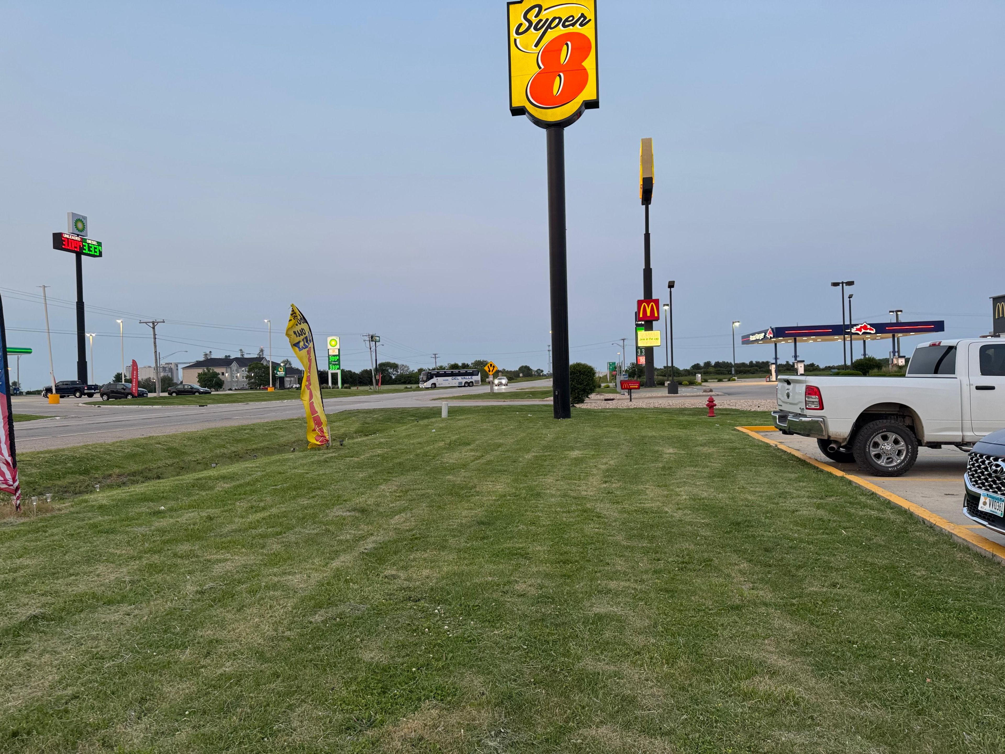 Un estacionamiento con un letrero de Super 8, un McDonald's y una parada de autobús.