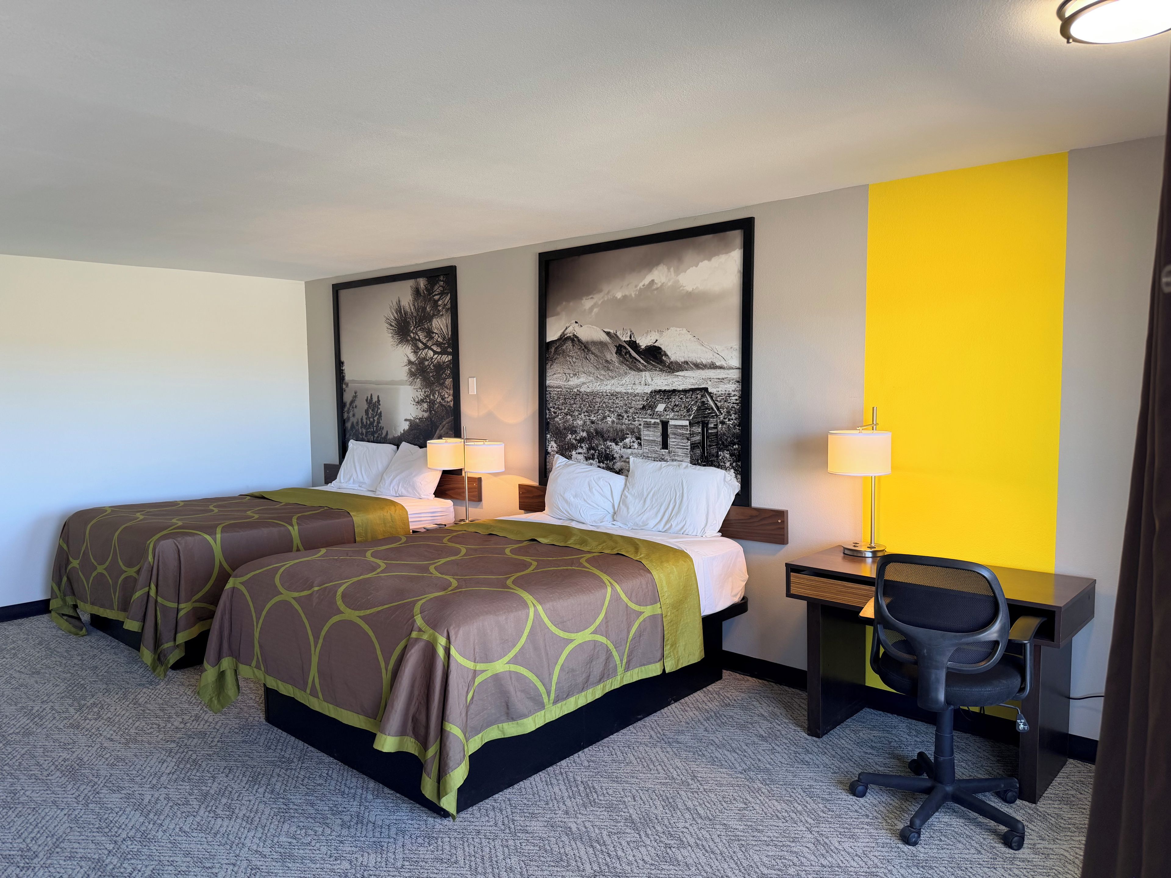 Una habitación de hotel con dos camas, un escritorio y una silla.