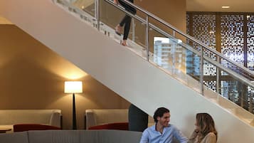 A modern interior with a staircase, seating area, and a lamp.