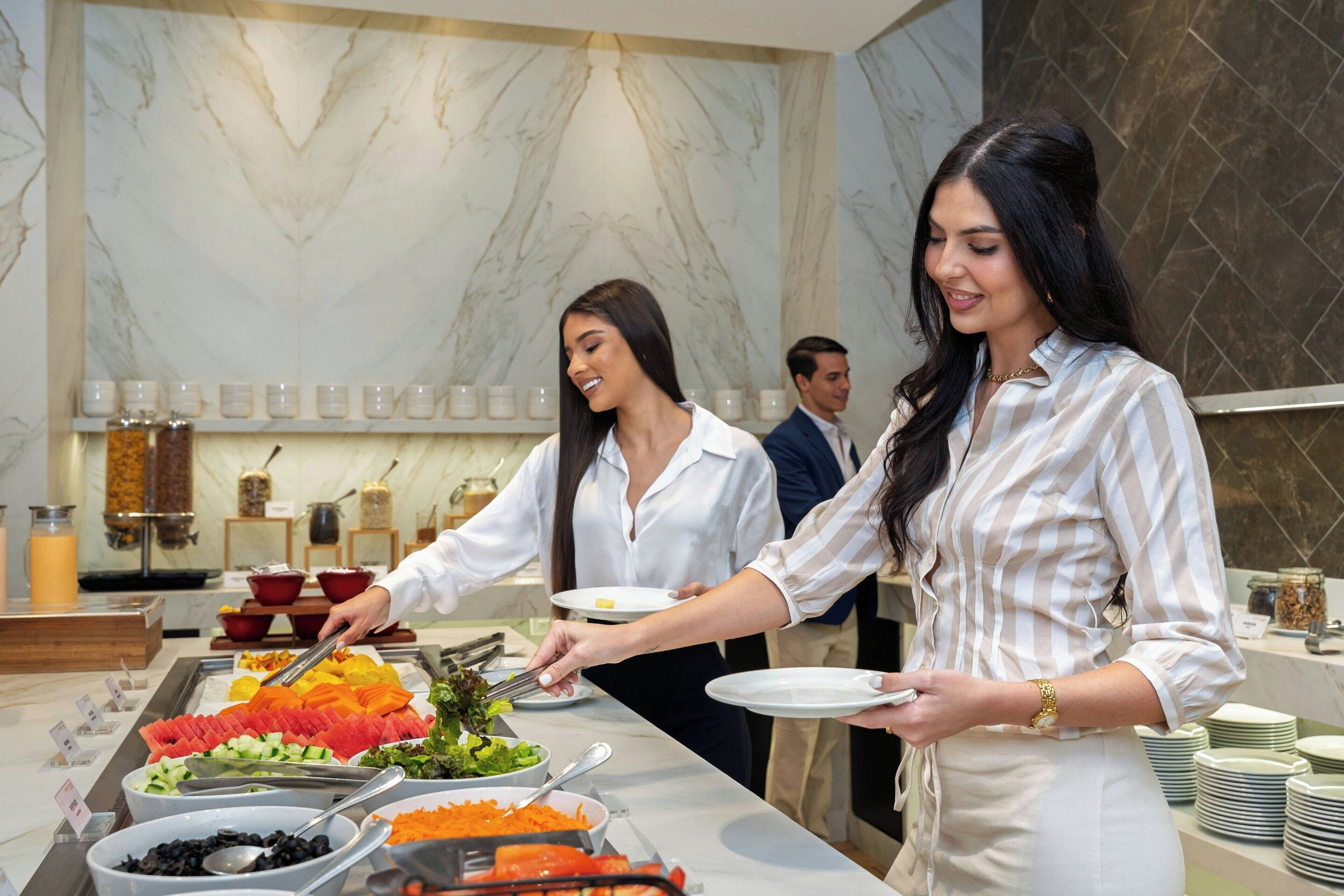 Ein reichhaltiges Buffet mit verschiedenen Speisen und einer Marmorwand im Hintergrund.