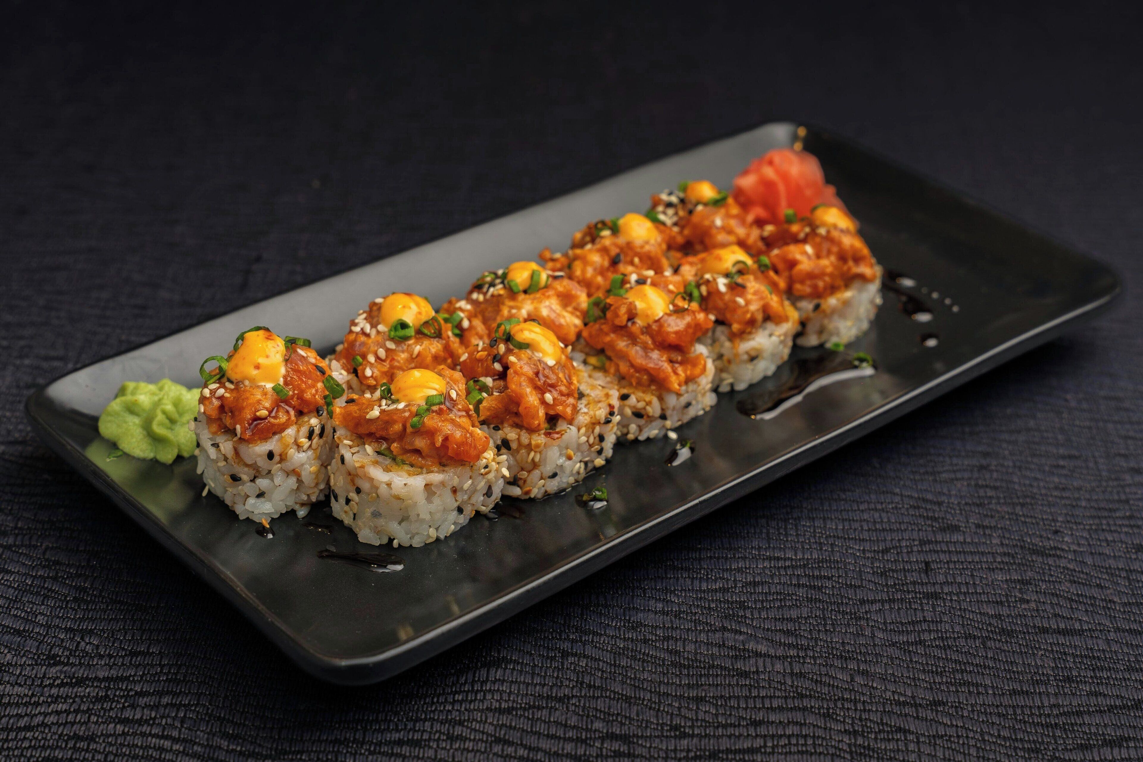 A sushi platter with six pieces of nigiri on a rectangular plate.