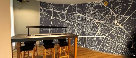 A dining area with a map mural, a table, and four chairs.