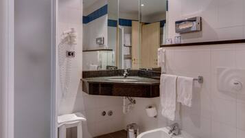 Un baño moderno con ducha, inodoro, bidé y lavamanos.