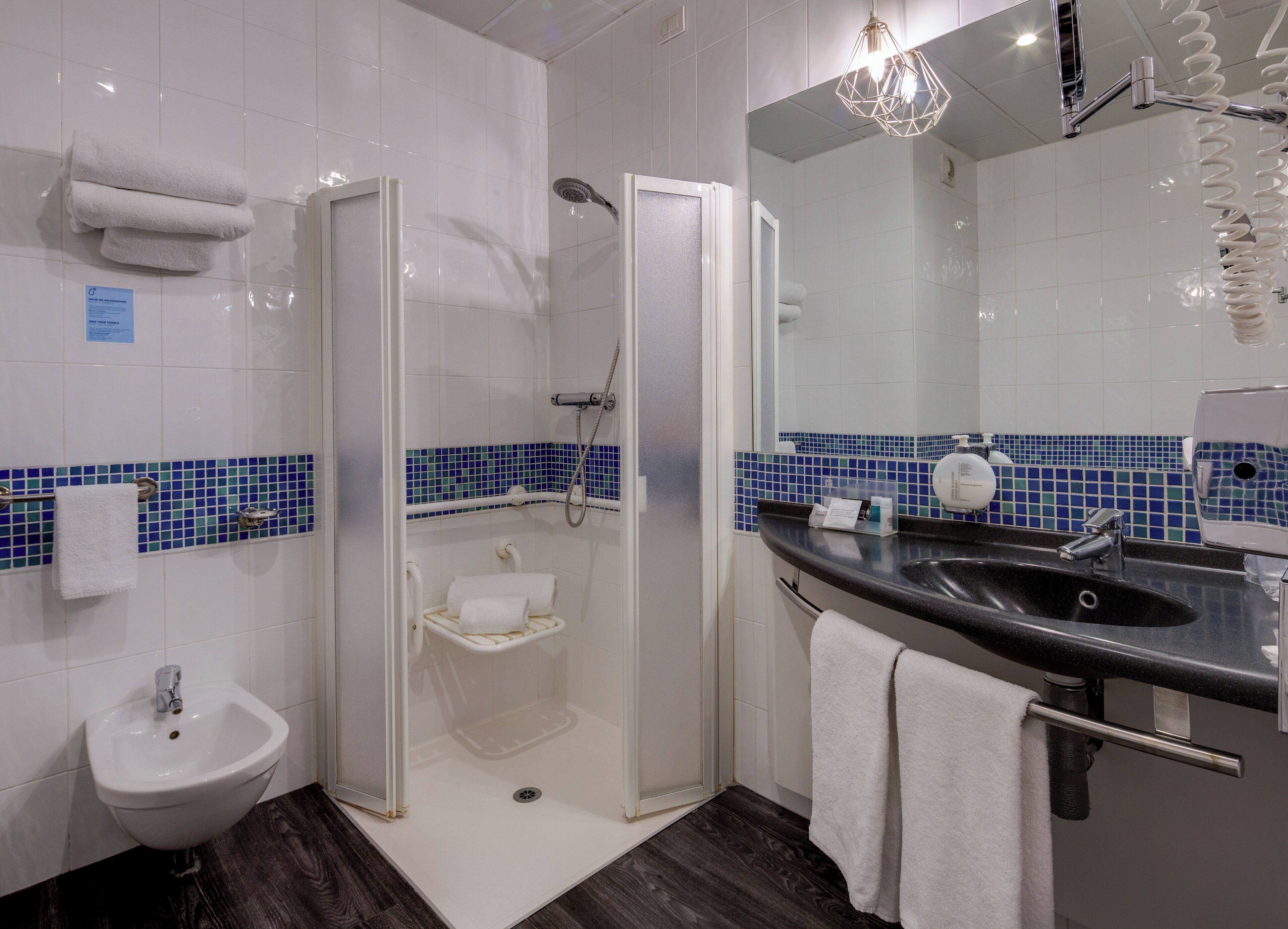 Une salle de bain avec douche, lavabo et bidet.