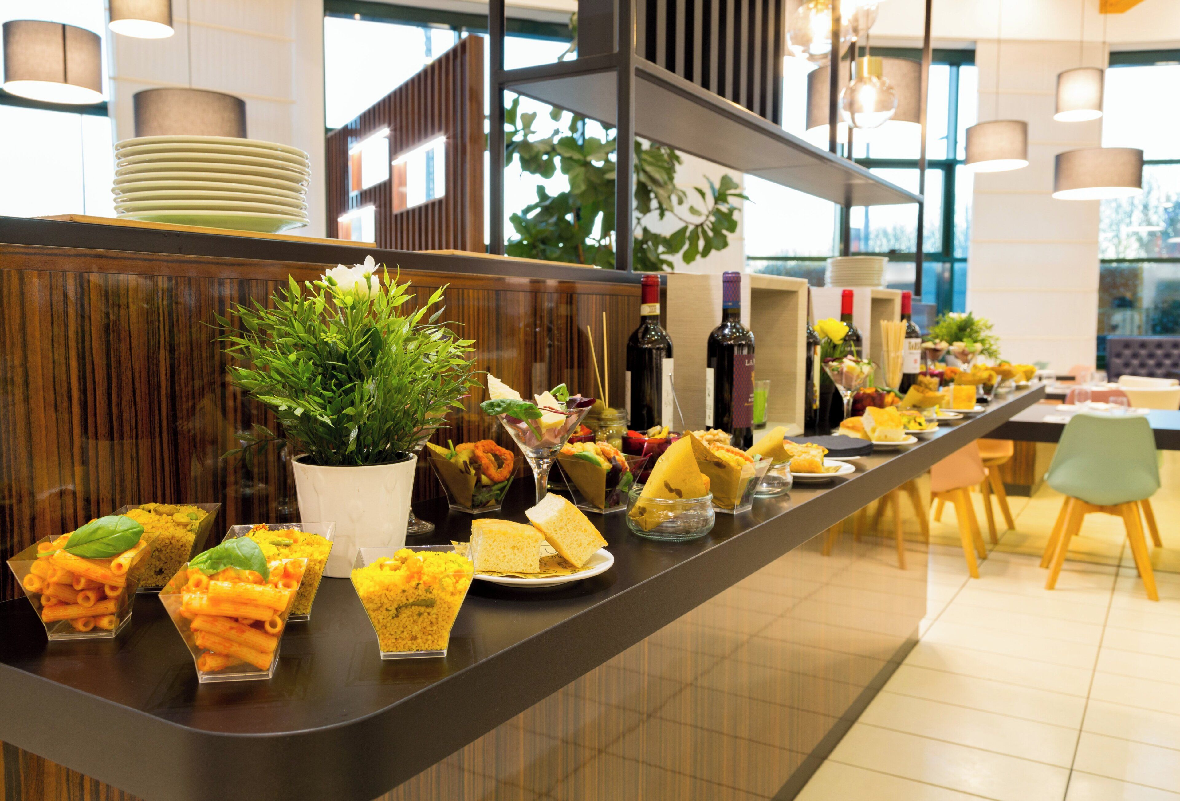 Un mostrador de buffet con diversos alimentos y una planta en maceta.