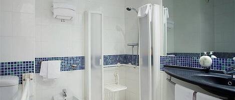 A modern bathroom with a shower, bidet, and sink.