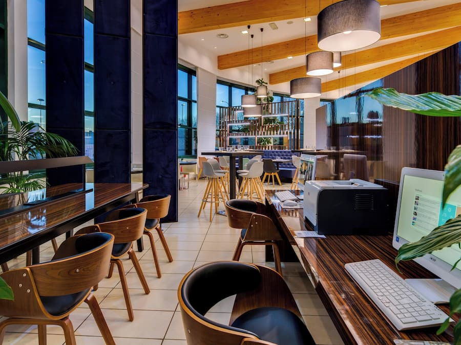 A modern office space with wooden desks, chairs, and a large computer monitor.