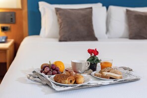 Un plateau de petit-déjeuner bien préparé est posé sur le lit d’un hôtel, offrant une vue sur la chambre.