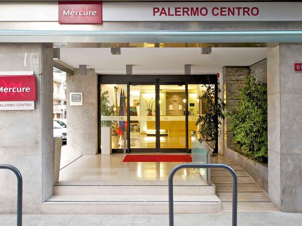 La entrada de un edificio con un letrero que dice "Mercure" y "PALERMO CENTRO".