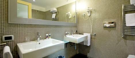 A bathroom with two sinks, a mirror, a hairdryer, and a towel rack.
