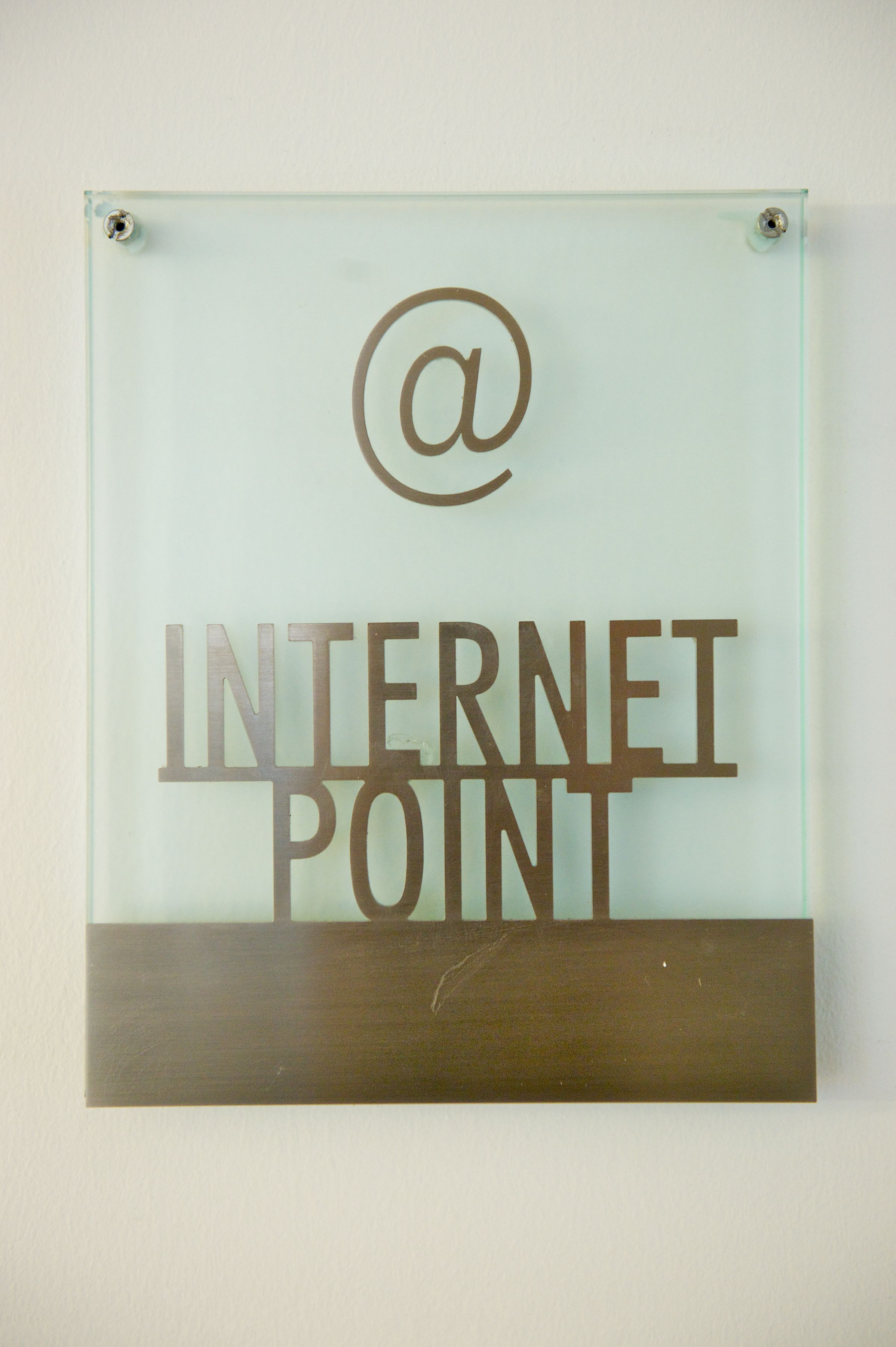 Une enseigne en verre portant l'inscription « POINT INTERNET » et le symbole « @ ».