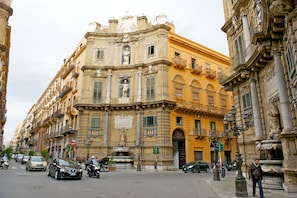 A historic building with classical architecture, a fountain, and a street with cars and pedestrians. - Mercure Hotel Palermo Centro (Palermo)