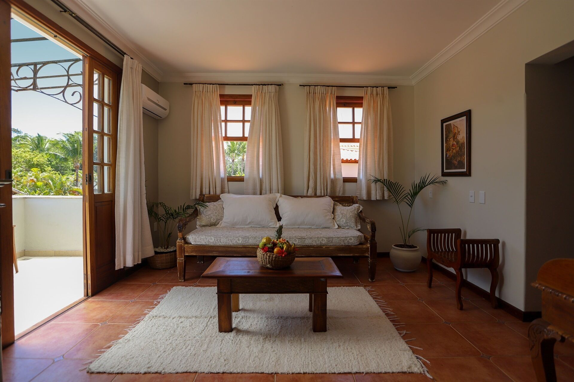A cozy living room with a sofa, a coffee table, and a potted plant.