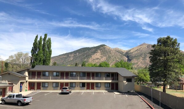 Un motel con estacionamiento, montañas al fondo y un letrero de Pepsi.