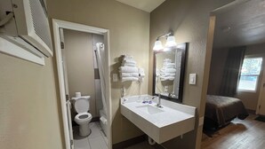 A bathroom with a toilet, sink, and towel rack. - Mountain View Inn (Flagstaff)