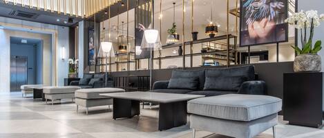 Un vestíbulo moderno con sofá, mesa de centro e iluminación colgante.