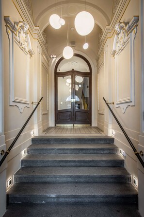 A grand staircase with ornate wall decorations and a large mirror at the top.