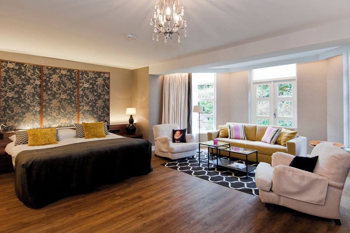 deluxe suite, jetted tub | minibar, in-room safe, desk, iron/ironing board