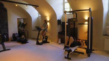 A gym with exercise equipment including treadmills, a bench press, and a squat rack.