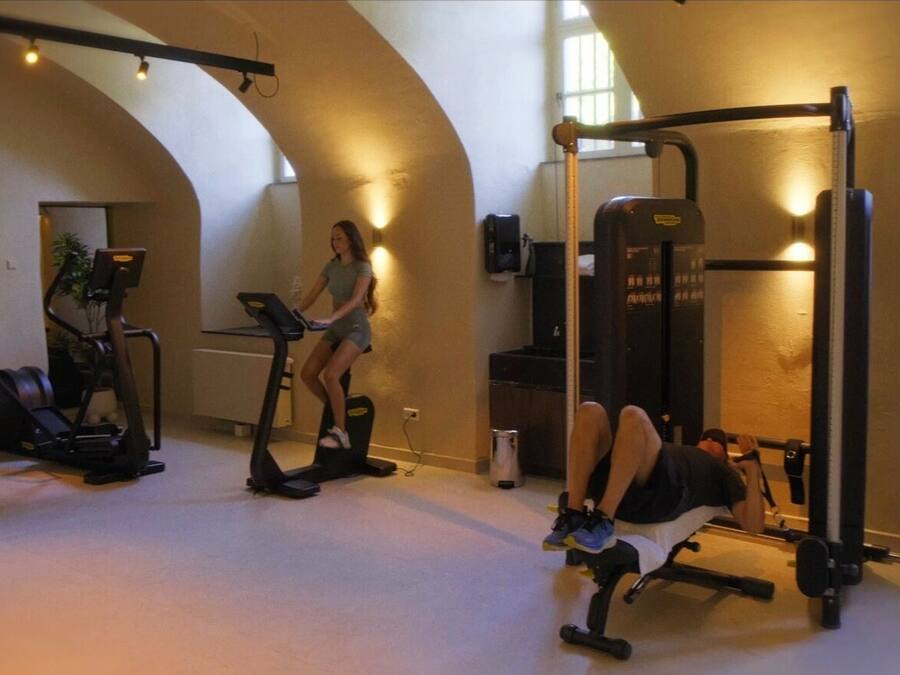 A gym with exercise equipment including treadmills, a bench press, and a squat rack.