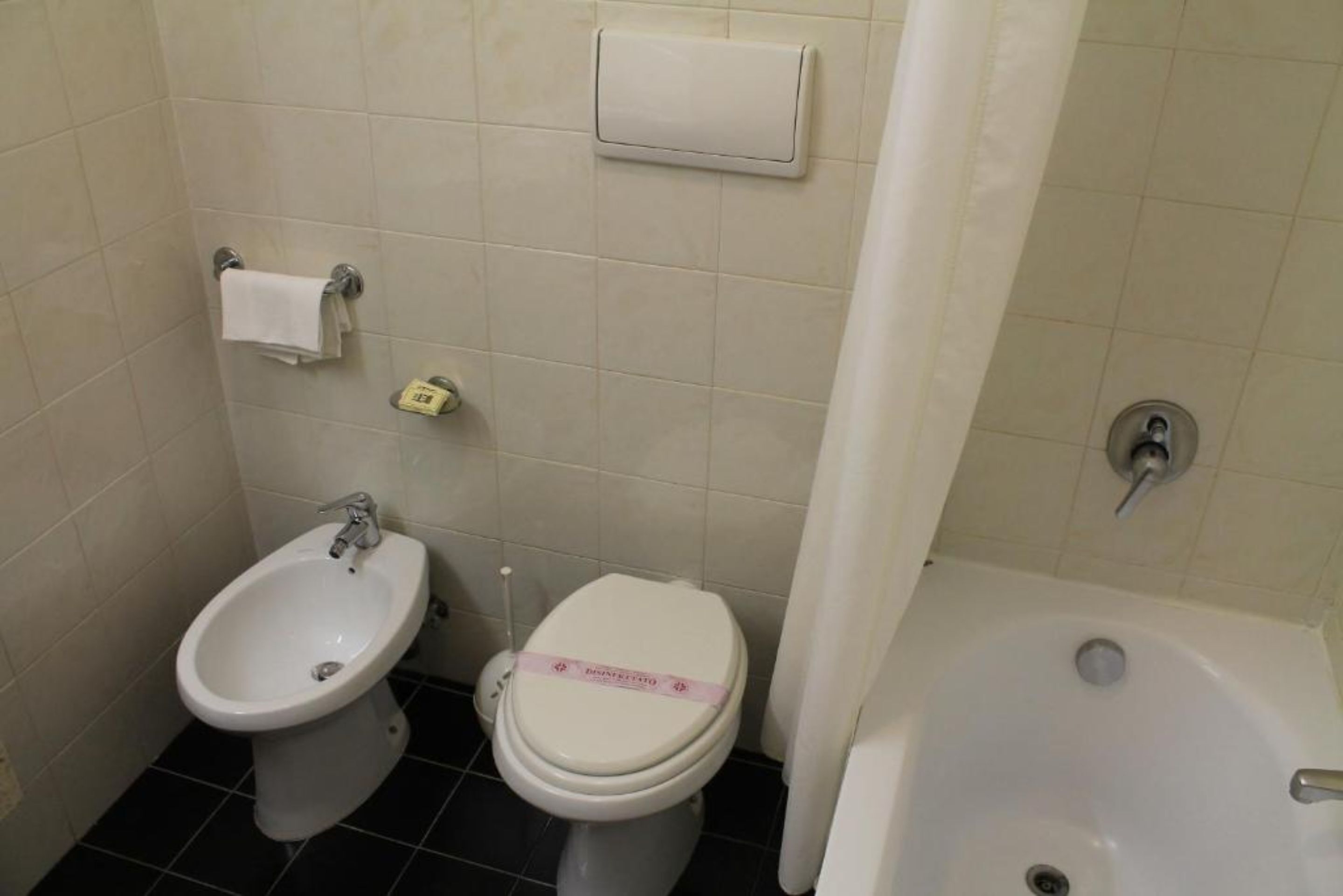 Un baño con bidé, inodoro y bañera.