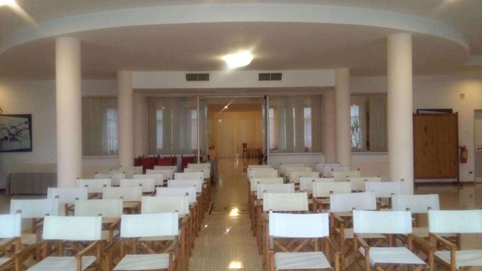 Ein Kircheninneres mit Reihen von Kirchenbänken, einem hölzernen Altar und einer großen, gewölbten Decke.