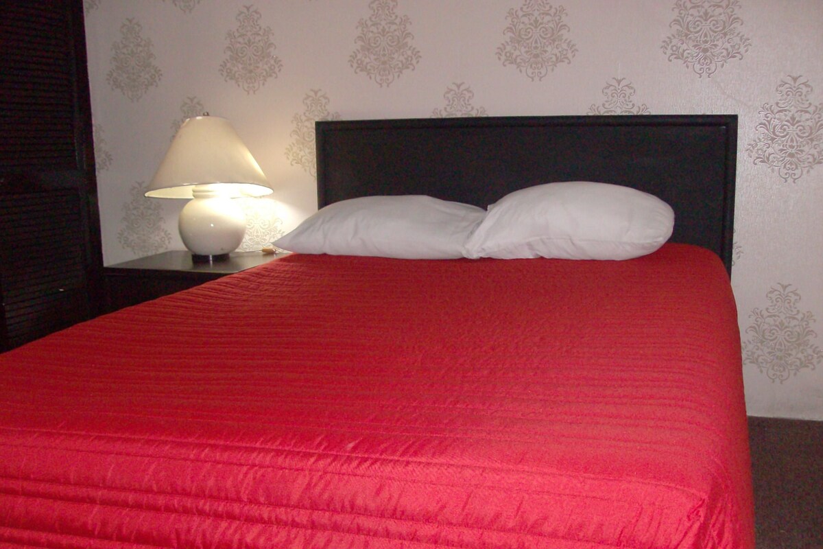 Escritorio, cortinas blackout y tabla de planchar con plancha