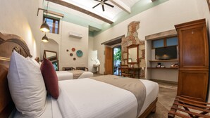 A bedroom with two beds, a wooden headboard, a brick wall, a television, and a wooden cabinet. - Casa De Sierra Azul (Oaxaca)