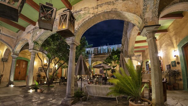 An indoor courtyard with stone arches, potted plants, and outdoor seating areas. - Casa De Sierra Azul (Oaxaca)